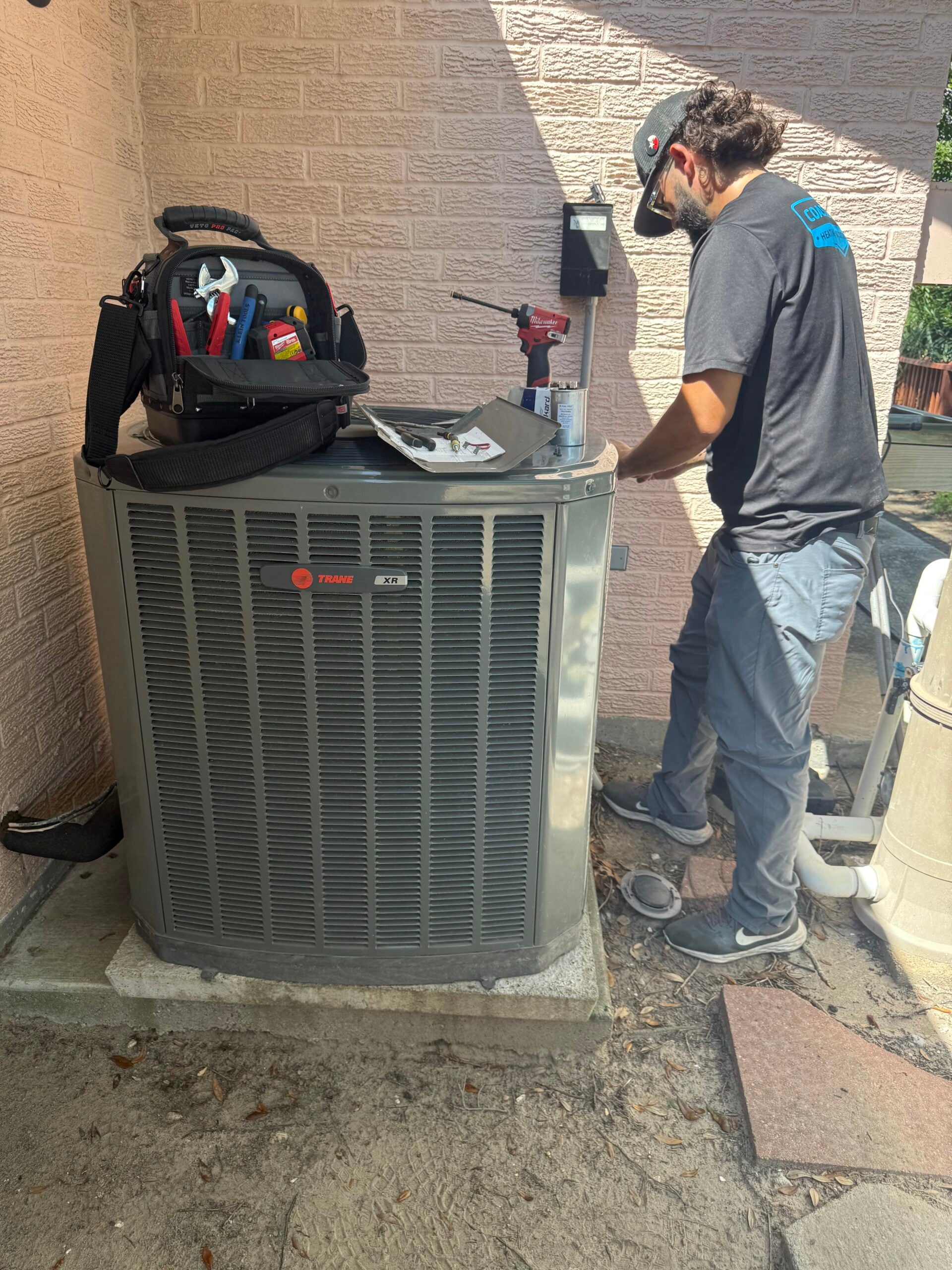 Coastal Comfort tech inspecting outdoor unit
